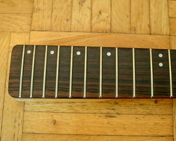 The no-name neck has little dots on the upper edge, I am thinking to remove these and fill the holes with brown wood filler so that you have some help with finding the right fret without changing the look of a board without dot markers.